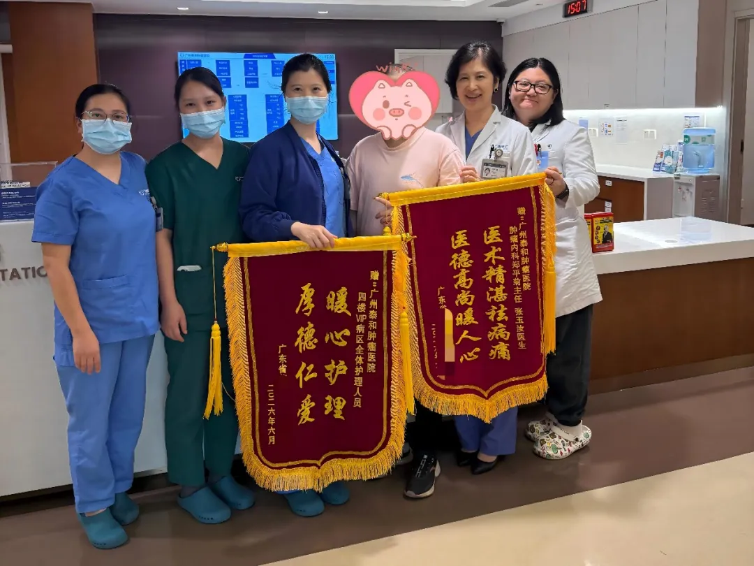 Patient presents thank-you flags to the Guangzhou Concord Cancer Center care team after treatment
